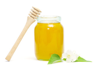 honey dipper and honey in jar on white background