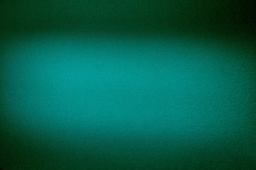 Blurred textural cloud of turquoise color on a dark green background