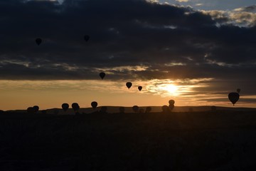 Fototapeta na wymiar Sunrise and balloons. Beautiful background of the balloon and the sunset.Cappadocia. Turkey. Göreme. Nevşehir. Türkiye. 8. 04. 2019. Balloons flying over the rocky landscape in Cappadocia Turkey. 