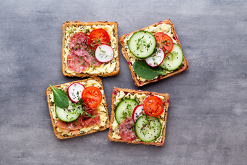 Sandwiches with cream cheese, vegetables and salami.