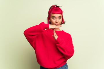 Young woman with red sweater making stop gesture with her hand to stop an act