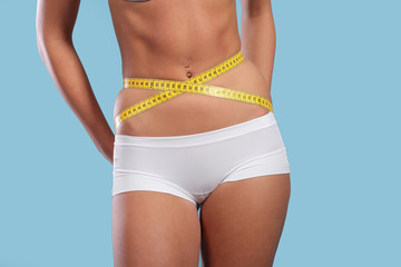 Fototapeta na wymiar Woman measuring her slim body