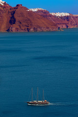 Santorini, touristic sailing ship in front of Oia coast, Greece