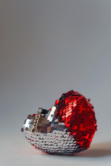 Key chain in the shape of a heart with double-sided sequins. Valentine's day gift. Texture of...