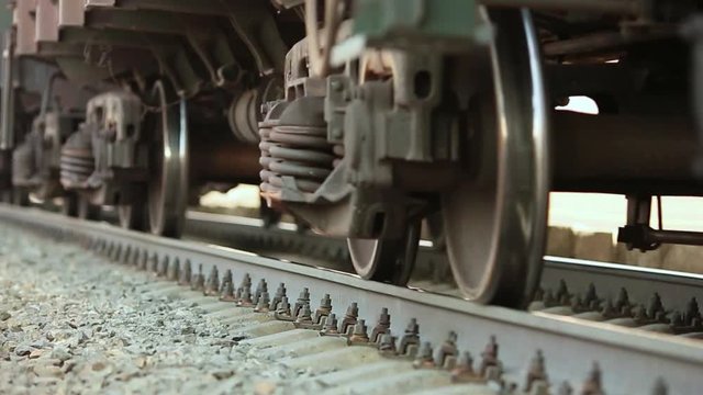 The wheels of old train on the railway track passing by camera. Close up shot