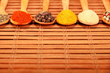 Group of indian spices and herbs difference ware in wooden spoons on wooden background with normal view and copy space for design foods, vegetable, spices, herbs, healthy lifestyle