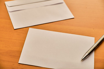Paper, envelope and ballpoint on table