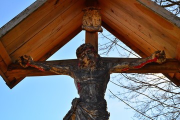 drewniany krzyż przydrożny z dużą figurą Chrystusa pod daszkiem 3
