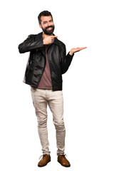 Naklejka premium Handsome man with beard holding copyspace imaginary on the palm to insert an ad over isolated white background