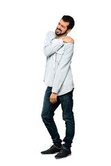 Naklejka premium Full-length shot of Handsome man with beard suffering from pain in shoulder for having made an effort over isolated white background