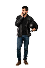 Full-length shot of Biker man nervous and scared putting hands to mouth over isolated white background