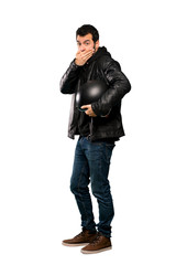 Fototapeta premium Full-length shot of Biker man covering mouth with hands over isolated white background