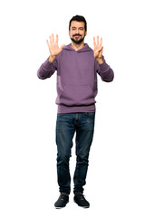 Full-length shot of Handsome man with sweatshirt counting eight with fingers over isolated white background