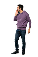 Fototapeta premium Full-length shot of Handsome man with sweatshirt shouting with mouth wide open to the lateral over isolated white background