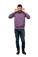 Full-length shot of Handsome man with sweatshirt with glasses and surprised over isolated white background