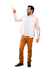 Fototapeta premium Full-length shot of Handsome man with beard pointing away over isolated white background