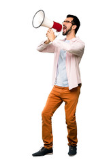 Full-length shot of Handsome man with beard shouting through a megaphone over isolated white background