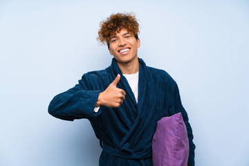 Young african american man in pajamas giving a thumbs up gesture