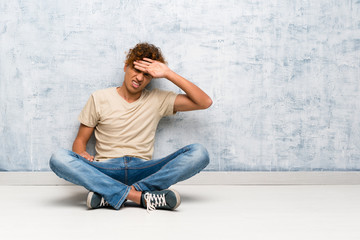 Young african american man sitting on the floor with tired and sick expression