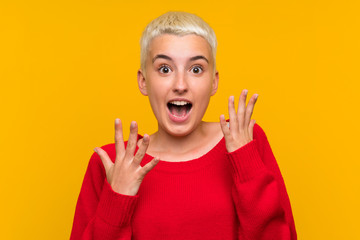 Teenager girl with white short hair over yellow wall with surprise facial expression