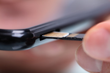 Person Inserting Sim Card In Cellphone