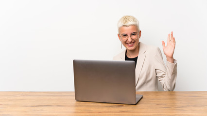 Teenager girl with short hair with a laptop smiling