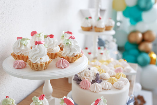 Cakes and sweets on a wooden shelf. The concept of decorating children's holiday.