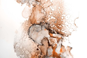 Orange alcohol ink texture with abstract washes and paint stains on the white paper background.	