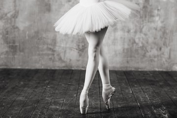 Ballerina in ballroom. Ballet dancer in studio. Black and white monochrome.