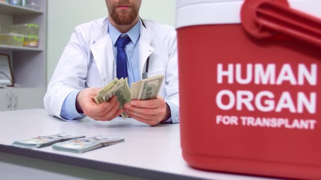 Doctor counting cache behind the organ trafficking container