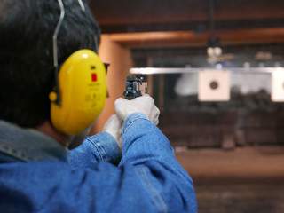 Man shooting a pistol in shooting range