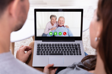 Couple Video Conferencing With Their Parents On Laptop