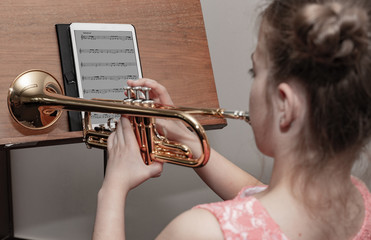 Mädchen spielt Trompete nach einer Musik-app