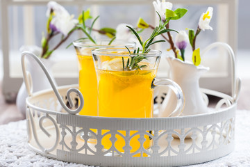 Fresh lemon drink with rosemary in glass cup