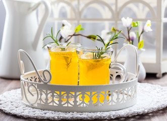 Fresh lemon drink with rosemary in glass cup