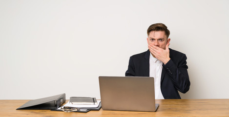 Businessman in a office covering mouth with hands