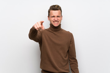Fototapeta premium Blonde man over isolated white wall frustrated and pointing to the front