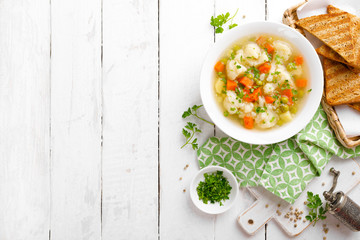 Vegetable soup with cauliflower, carrot, green peas, onion and potato