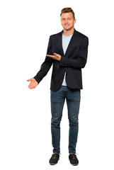 Blonde handsome man presenting an idea while looking smiling towards