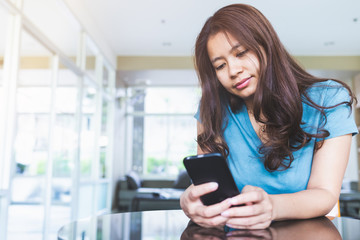 Close up portrait of an asian women typing text in a mobile phone