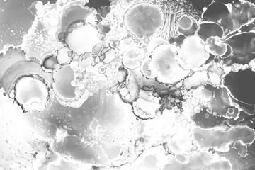 Gray alcohol ink texture with abstract washes and paint stains on the white paper background.