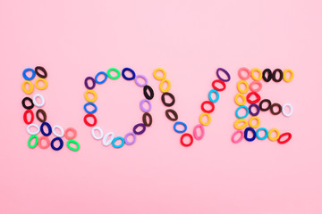The word Love in the form of multi-colored hair elastics