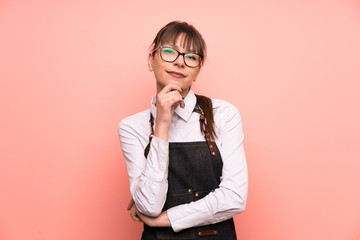 Young waitress over pink background laughing