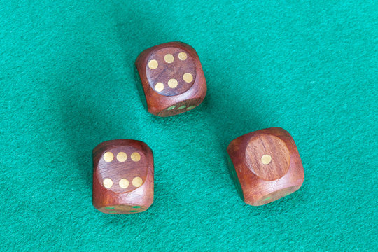 Three Wooden Dices On Green Baize Table