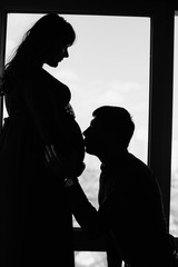 silhouette of a couple waiting for a child