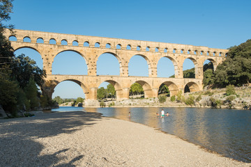 Fototapeta premium Family swimming in the Gardón river, very close to the Roman aqueduct Pont du Gard. France, Europe