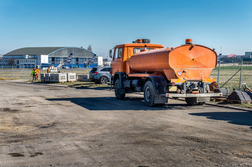 Construction site of road, building or airport with construction machinery (truck, bulldozer, excavator) and construction workers or engineers