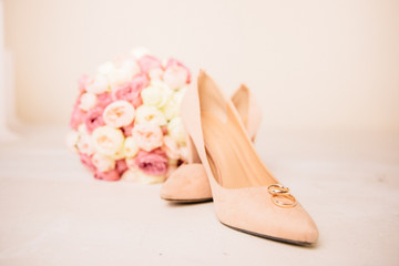wedding rings on shoes and with a bouquet of the bride