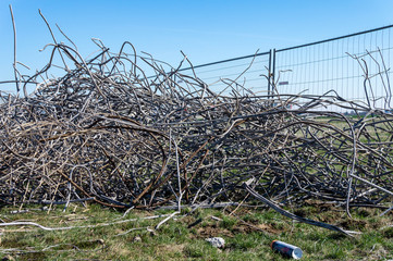 Waste and mess on construction site of road, building or airport with grass and fence