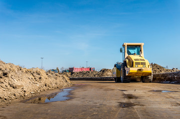 Construction site of road, building or airport with construction machinery (truck, bulldozer, excavator) and construction workers or engineers